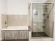 Modern bathroom featuring a soaking tub with decorative stone surround, and glass-enclosed shower with a stone floor at 2037 Ruckle St, Indianapolis, IN 46202