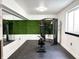 Modern home gym featuring exercise machine, mirrors, and an artificial turf accent wall at 2037 Ruckle St, Indianapolis, IN 46202