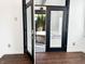 View through open glass doors to the covered patio with a hot tub and privacy trees at 2037 Ruckle St, Indianapolis, IN 46202