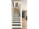 Elegant staircase with dark wood treads and handrail, leading to an open living space at 2037 Ruckle St, Indianapolis, IN 46202