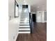 Open staircase design with dark hardwood floors, black railing, and natural light, creates an inviting and modern aesthetic at 2037 Ruckle St, Indianapolis, IN 46202