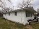 A side view of the home showing vinyl siding, window placement, and front porch at 2194 N Riley Ave, Indianapolis, IN 46218