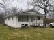 Single-story home with a compact front porch and accessibility ramp on a partly sunny day at 2194 N Riley Ave, Indianapolis, IN 46218