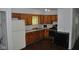 Kitchen with wood cabinets, laminate counters, white appliances, and dark flooring at 2194 N Riley Ave, Indianapolis, IN 46218