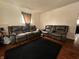 Inviting living room with hardwood floors, black rug, and two brown leather couches at 2194 N Riley Ave, Indianapolis, IN 46218