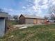 Backyard image showing a house with plywood exterior and a detached garage at 2860 S Rybolt Ave, Indianapolis, IN 46241