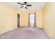 A cozy bedroom painted in yellow tones featuring a ceiling fan and ample light at 2885 Holiday Way, Greenwood, IN 46143