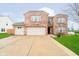 Two-story brick home featuring a three-car garage, well-manicured lawn, and a welcoming front entrance at 2885 Holiday Way, Greenwood, IN 46143