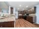 Modern kitchen featuring stainless steel appliances, rich wood cabinetry, stylish backsplash, and durable laminate flooring at 2885 Holiday Way, Greenwood, IN 46143