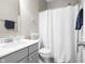 Clean, well-lit bathroom with gray vanity, a shower with white curtain, and coastal-themed decor at 4148 Basswood Dr, Danville, IN 46122