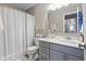 A well-lit bathroom features modern vanity with soft gray cabinets and a shower with white curtain at 4148 Basswood Dr, Danville, IN 46122