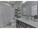 Well-lit bathroom with a single sink vanity, decorative shelves, and a floral patterned shower curtain at 4182 Backstretch Ln, Bargersville, IN 46106
