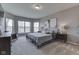 Bright bedroom featuring a bed with a gray comforter, bay window, and neutral decor at 4182 Backstretch Ln, Bargersville, IN 46106