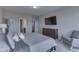 Bedroom with a view to a bathroom, mounted TV, dresser, and chair at 4182 Backstretch Ln, Bargersville, IN 46106