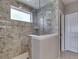 Shower with stone-look tile surround, glass partition, and window at 4182 Backstretch Ln, Bargersville, IN 46106