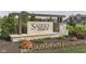 Close up of the Saddle Club sign that is framed by landscape, mulch, and a pond at 4182 Backstretch Ln, Bargersville, IN 46106