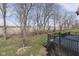 Backyard view of wood deck and railing, with trees and green grass at 4182 Backstretch Ln, Bargersville, IN 46106