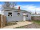 Home's backyard featuring a patio, light gray siding, and a red-brick chimney at 5309 E 19Th Pl, Indianapolis, IN 46218