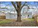 Large backyard featuring a detached garage, gray siding, and mature trees at 5309 E 19Th Pl, Indianapolis, IN 46218