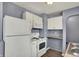 View of the kitchen featuring white appliances and cabinets, microwave, and laminate countertops at 5309 E 19Th Pl, Indianapolis, IN 46218