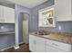 Cozy kitchen with white cabinets, granite-look countertops, and stainless steel sink under a bright window at 5309 E 19Th Pl, Indianapolis, IN 46218
