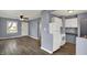 Open-concept view shows living room, kitchen with white appliances, and stylish wood flooring at 5309 E 19Th Pl, Indianapolis, IN 46218