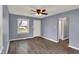 Open living room with gray walls, updated ceiling fan, fresh white trim, and modern wood-look floors at 5309 E 19Th Pl, Indianapolis, IN 46218