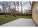 Spacious backyard featuring a concrete patio area, mature trees, and a lush, grassy lawn at 5915 Lowell Ave, Indianapolis, IN 46219