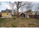 Large backyard with mature trees, shed, fire pit, and a patio near the house at 5915 Lowell Ave, Indianapolis, IN 46219
