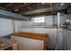 Unfinished basement area showing a window, wooden beams and a work area at 5915 Lowell Ave, Indianapolis, IN 46219