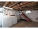 Basement laundry area with exposed ceiling and utility sink near a staircase at 5915 Lowell Ave, Indianapolis, IN 46219