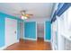 Bedroom with wood floors, blue walls, white trim, and a ceiling fan, offering a comfortable living space at 5915 Lowell Ave, Indianapolis, IN 46219