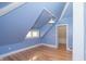 Attic bedroom with sloping ceilings, light blue walls, hardwood floors, and a cozy atmosphere with natural light at 5915 Lowell Ave, Indianapolis, IN 46219