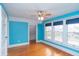 Bright bedroom featuring wood floors, blue walls, a ceiling fan, and windows providing natural light and views at 5915 Lowell Ave, Indianapolis, IN 46219