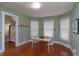 Dining room features hardwood floors, three windows, light green walls, and entry to the staircase at 5915 Lowell Ave, Indianapolis, IN 46219