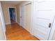 Hallway featuring hardwood floors, white doors, and trim, creating a clean and classic aesthetic at 5915 Lowell Ave, Indianapolis, IN 46219