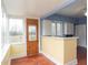 Cozy kitchen featuring retro white cabinets and hardware, a breakfast bar and an outside view at 5915 Lowell Ave, Indianapolis, IN 46219