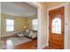 Inviting living room with hardwood floors, bright yellow walls, and a view of the front door at 5915 Lowell Ave, Indianapolis, IN 46219