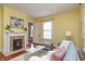 Living room with a fireplace, hardwood floors, a plush couch, and warm yellow walls at 5915 Lowell Ave, Indianapolis, IN 46219