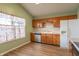 Cozy kitchen with warm wood cabinetry, stainless steel dishwasher, and adjacent view to dining area at 607 N White Ash N Ct, Mooresville, IN 46158