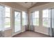 Light-filled sun room featuring multiple windows, neutral paint, carpet, and access to the backyard at 607 N White Ash N Ct, Mooresville, IN 46158