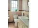 Classic bathroom featuring retro pink and white tile, large window, and marble-look vanity at 6105 E St Joseph St, Indianapolis, IN 46219