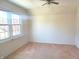 Cozy bedroom with a ceiling fan, carpeted floors, and natural light from large windows at 6105 E St Joseph St, Indianapolis, IN 46219