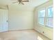 Sunny bedroom with a ceiling fan, neutral carpet and two large windows offering tree-lined views at 6105 E St Joseph St, Indianapolis, IN 46219