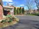 Long paved driveway leads to a brick home, featuring mature trees, and landscaping at 6105 E St Joseph St, Indianapolis, IN 46219