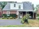 Cozy home featuring brick accents, an awning, and a covered porch surrounded by lush greenery at 6105 E St Joseph St, Indianapolis, IN 46219
