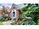 Close up view of a brick home's entrance, enhanced by vibrant flower beds and an ADT security system at 6105 E St Joseph St, Indianapolis, IN 46219