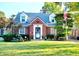 Charming brick home featuring dormer windows, manicured lawn, American flag, and inviting curb appeal at 6105 E St Joseph St, Indianapolis, IN 46219