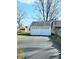 Detached two-car garage with white siding and decorative windows, set on a paved driveway at 6105 E St Joseph St, Indianapolis, IN 46219