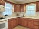 Traditional kitchen featuring wooden cabinets, neutral countertops, and bright natural light from two windows at 6105 E St Joseph St, Indianapolis, IN 46219